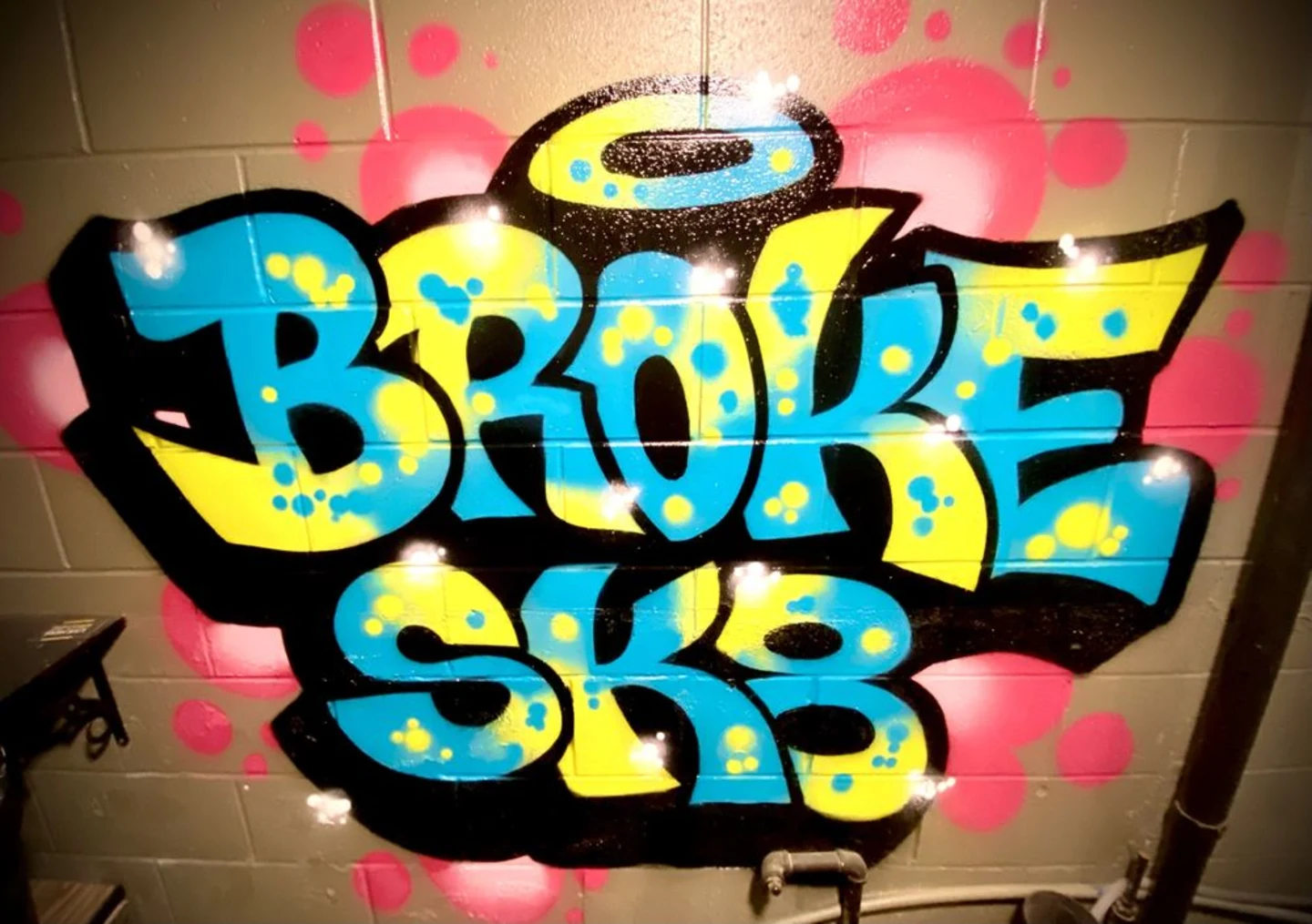 Colorful Broke Sk8 bubble-letter graffiti on the shop's cinder block wall